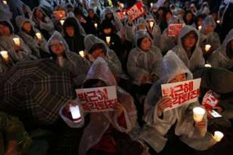 Sambil menyalakan lilin saat berkerumun di pusat Seoul, ibu kota Korea Selatan, Sabtu (19/11/2016), massa warga berseru berulangkali 