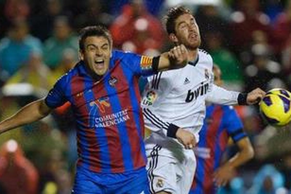 Bek Levante, Sergio Ballesteros (kiri), tengah berebut bola melawan bek Real Madrid, Sergio Ramos, dalam laga pekan ke-11 di Stadion Ciutat de Valencia, Minggu (11/11/2012). 