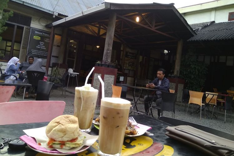 Pengunjung menikmati penganan di Hip Burger, Jalan Mesrah Pendopo, Aceh Tengah, Minggu (16/10/2017).