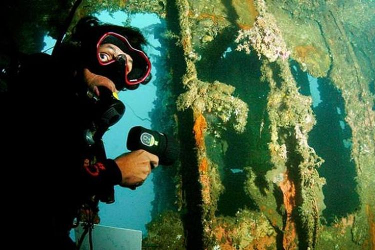 Penyelam di dalam bagian kapal Mawali yang terdampar di dasar laut perairan Selat Lembeh. Sejumlah ruang yang dapat dimasuki cukup aman untuk dijelajahi.