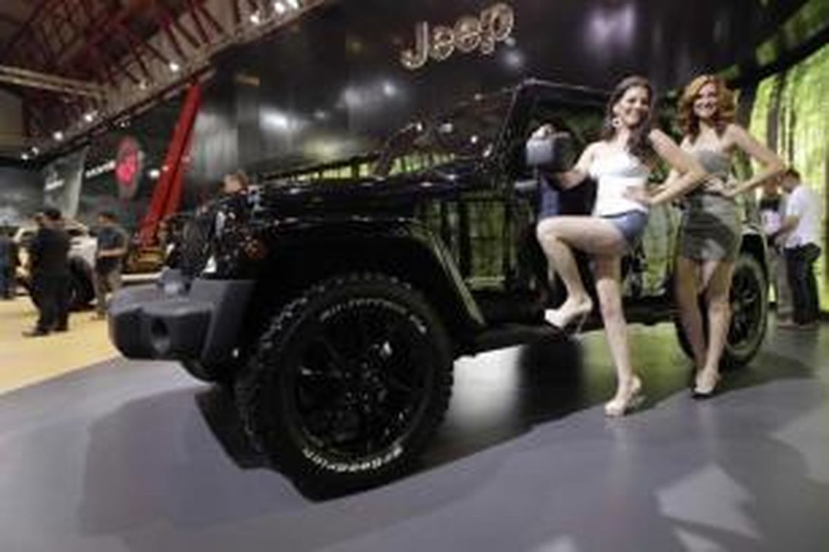 Model berpose di samping mobil terbaru Jeep Wrangler Sahara, saat peluncuran di 22nd Indonesia International Motor Show 2014, di JIExpo, Jakarta, Jumat (19/9/2014). Mobil ini menggunakan mesin HEMI dengan kapasitas 6,4 liter dan mampu menghasilkan 470 tenaga kuda.