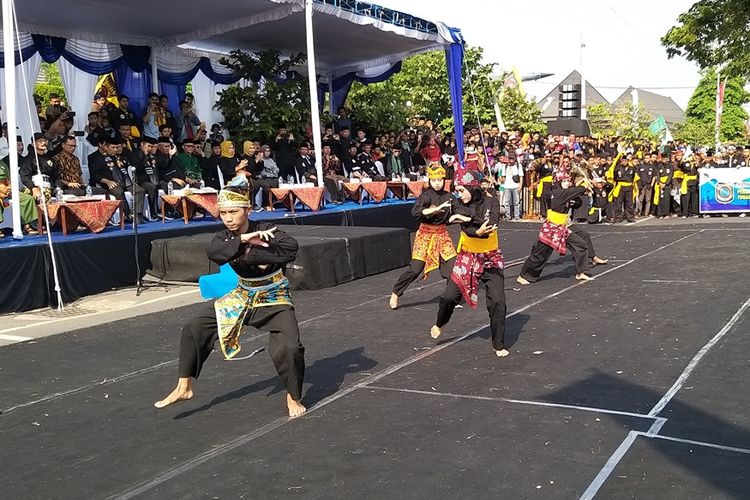 Salah satu perguruan pencak silat menampilkan gerakan bela diri dalam pawai memperingati satu tahun Kabupaten Madiun sebagai Kampung Pesilat Indonesia di alun-alun Kota Caruban, Kabupaten Madiun, Jawa Timur, Minggu (27/10/2019).