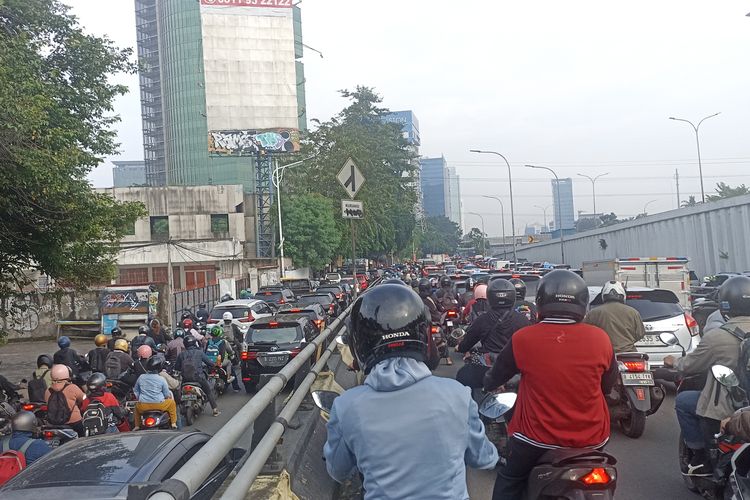 Riki (29) sempatkan merokok di tengah kepadatan lalu lintas TB Simatupang