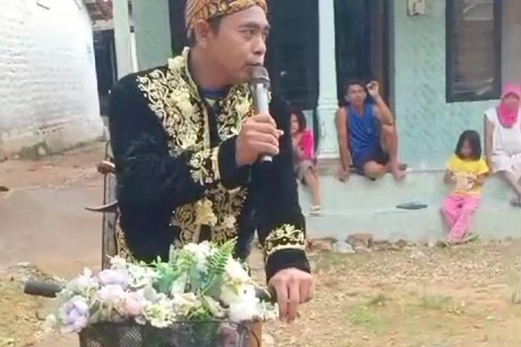 Seorang pria yang mengenakan pakaian pengantin keliling kampung di Sumenep, Senin (12/2/2024). Ia mengajak warga tak golput dalam Pemilu 2024 pada 14 Februari 2024.