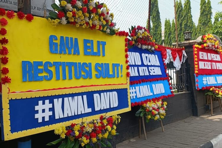 Karangan bunga berisi pesan sindiran untuk terdakwa penganiayaan yang dilakukan oleh Mario Dandy Satriyo, Selasa (15/8/2023) di trotoar Pengadilan Negeri Jakarta Selatan. Gaya Elit, Restitusi Sulit, adalah kalimat sindiran yang tertulis di karangan bunga tersebut.