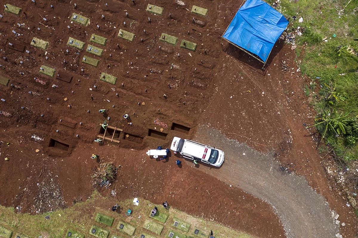 Foto dirilis Sabtu (19/9/2020), memperlihatkan petugas penggali makam jenazah Covid-19 bersiap menurunkan peti di kompleks pemakaman Pondok Ranggon. Selain tenaga medis yang menjadi garda terdepan penanganan virus corona, salah satu pahlawan lain juga patut diberikan apresiasi tinggi adalah petugas pemakaman jenazah Covid-19.