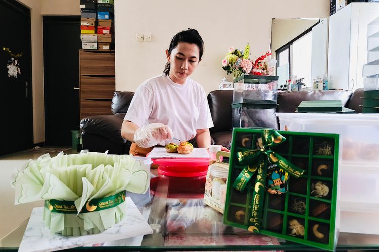 Melissa Juliani sedang menghias kue soes nya yang dipesan pelanggannya untuk hampers Lebaran 2025. 