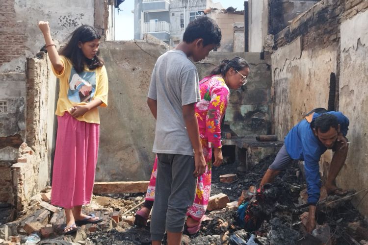 Ratih (35) dan keluarganya sedang mengais puing-puing sisa rumahnya yang terbakar, Senin (8/4/2024).