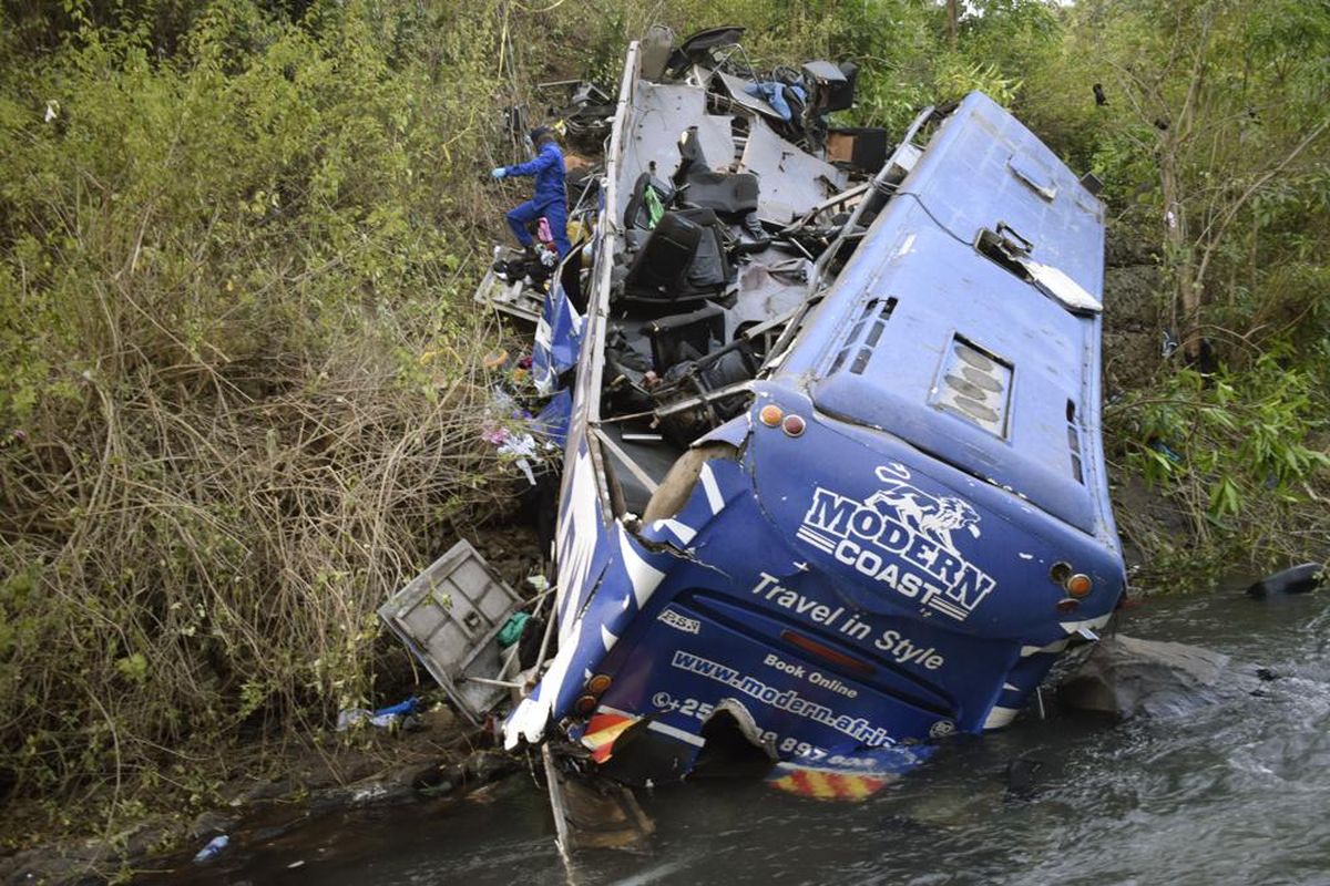 Orang-orang melihat puing-puing bus yang jatuh ke jembatan Nithi pada hari Minggu (24/7/2022), di kabupaten Tharaka Nithi Meru, Kenya, Senin (25/7/2022). Polisi di Kenya mengatakan setidaknya 21 orang tewas setelah sebuah bus jatuh dari jembatan dan jatuh ke sungai di sepanjang jalan raya dari ibu kota, Nairobi, ke pusat kota Meru. Seorang polisi senior mengatakan, bus yang berangkat dari Meru, ?pasti mengalami rem blong karena kecepatannya sangat tinggi? saat kecelakaan terjadi.