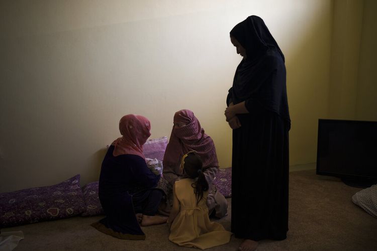Mujdha, kiri, menggendong putrinya yang berusia 13 hari saat dia berbicara dengan Razia dan putrinya Alia di dalam bagian wanita penjara Pul-e-Charkhi di Kabul, Afghanistan, Kamis, 23 September 2021. 