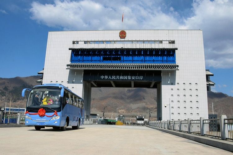 Bus yang membawa wisatawan dari China melintasi gerbang perbatasan baru menuju Korea Utara di kota Jian, Senin (8/4/2019).