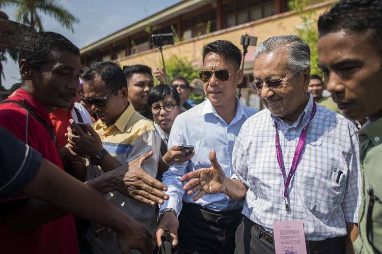 Politisi senior Malaysia, Mahathir Mohamad dari koalisi Pakatan Harapan, menyapa sejumlah pendukungnya setelah memberikan suaranya dalam pemilhan umum, di tempat pemungutan suara di Alor Setar, Malaysia, Rabu (9/5/2018). Pemilu yang berlangsung hari ini menjadi pertarungan sengit Perdana Menteri Petahana Najib Razak, dan mantan PM Mahathir Mohamad.