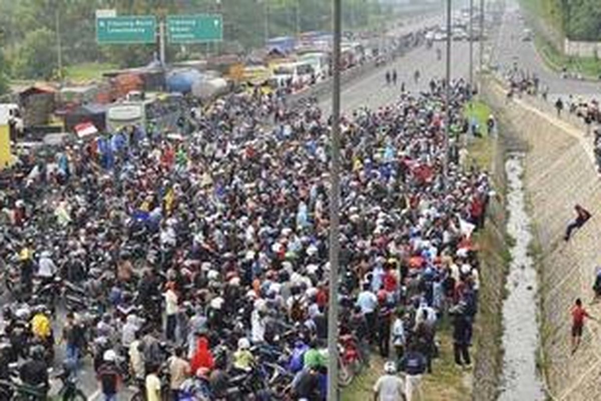 Unjuk rasa buruh dengan menutup tol Jakarta-Cikampek di sekitar pintu tol Cikarang Barat, Bekasi, Jumat (27/1/2012).  