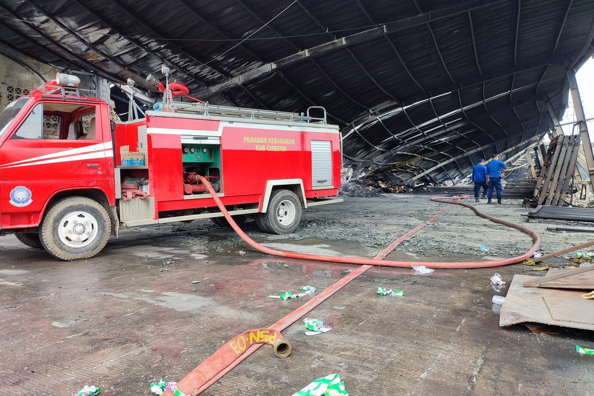 Dua petugas pemadam kebakaran kabupaten Cirebon Jawa Barat, menunjukkan bagian sisa kebakaran di PT Aiyi Desa Kebonturi, kecamatan Arjawinangun, pada Senin (24/2023)