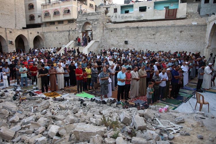 Warga Palestina melaksanakan salat subuh Idul Adha di halaman Masjid Omari yang bersejarah di Kota Gaza, yang rusak berat akibat pemboman Israel selama pertempuran yang sedang berlangsung antara Israel dan Hamas, pada 16 Juni 2024.