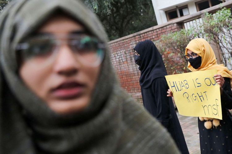 Seorang mahasiswa Muslim memegang kertas tuntutan selama protes oleh Federasi Mahasiswa Muslim (MSF) terhadap larangan jilbab baru-baru ini di beberapa perguruan tinggi Karnataka, di New Delhi, India, Selasa (8/2/2022).