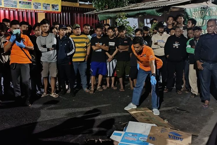 Petugas polisi saat tiba dan mengevakuasi jasad seorang pria yang tewas Jalan Mustikasari nomor 4 RT 006 RW 018, Pengasinan, Rawalumbu, Bekasi Timur, Senin (24/7/2023) malam. Pemuda itu diduga jadi korban tawuran.