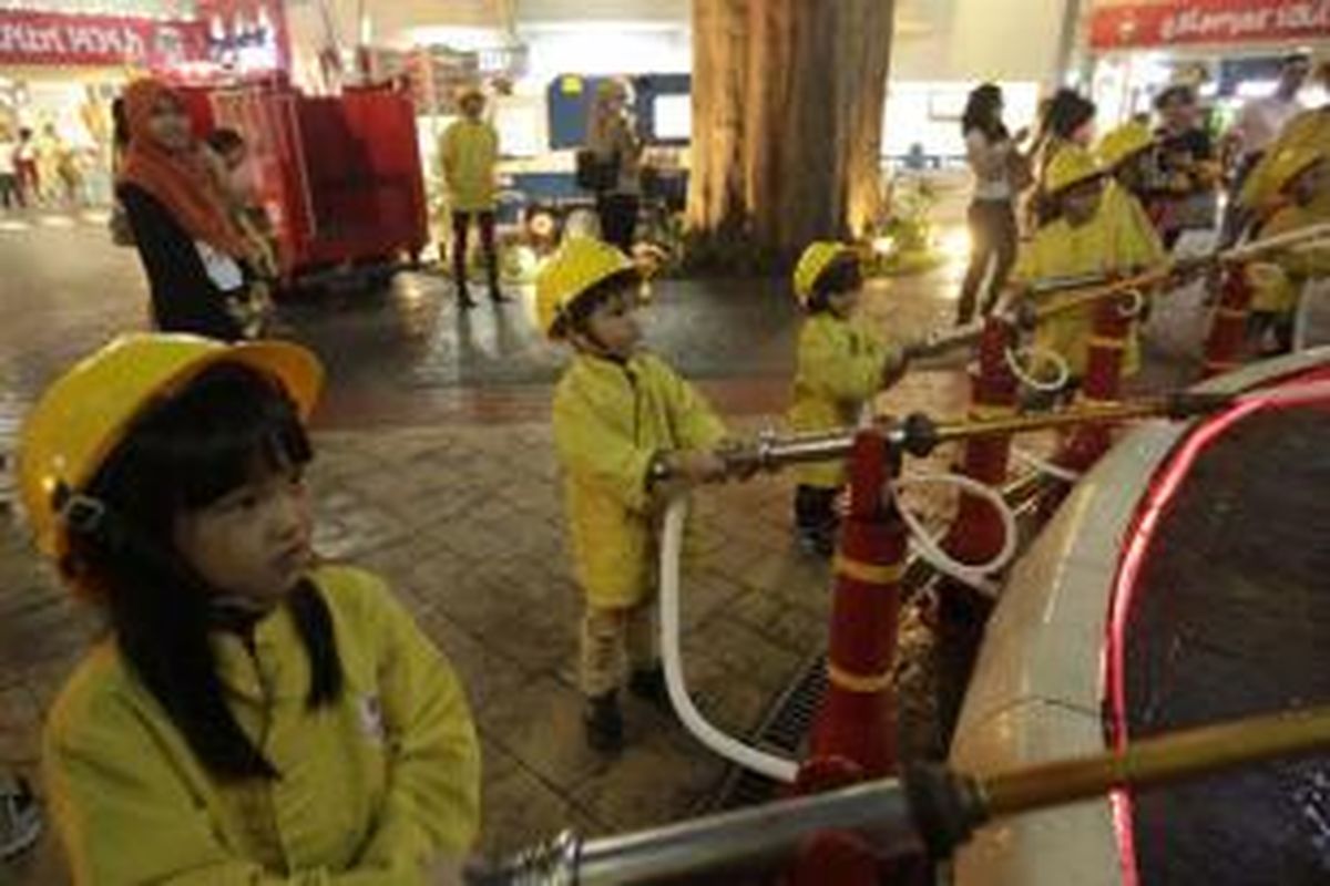 Anak-anak berprofesi sebagai pemadam kebakaran saat bermain di Kidzania, Pacific Place, Jakarta, Senin (5/8/2013).  