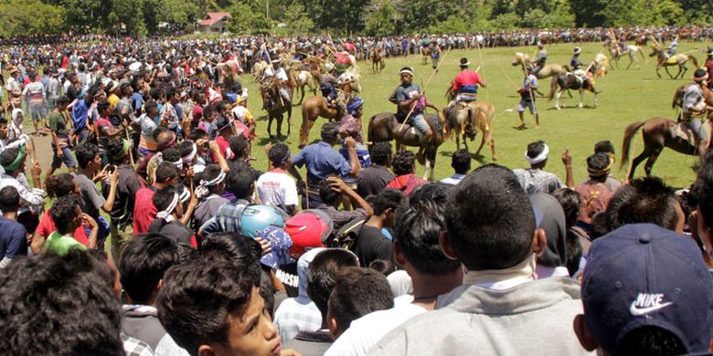 Warga dan wisatawan dalam dan luar negeri menyaksikan atraksi lempar kayu antar penunggang kuda dalam Festival Pasola, di Kecamatan Wanokaka, Kabupaen Sumba Barat, NTT, Selasa (26/2/2019). Festival Pasola Wanokaka yang digelar satu tahun sekali itu sebagai bagian dari kegiatan menjaga adat dan tradisi masyarakat Sumba, khususnya Merapu agama asli orang Sumba.