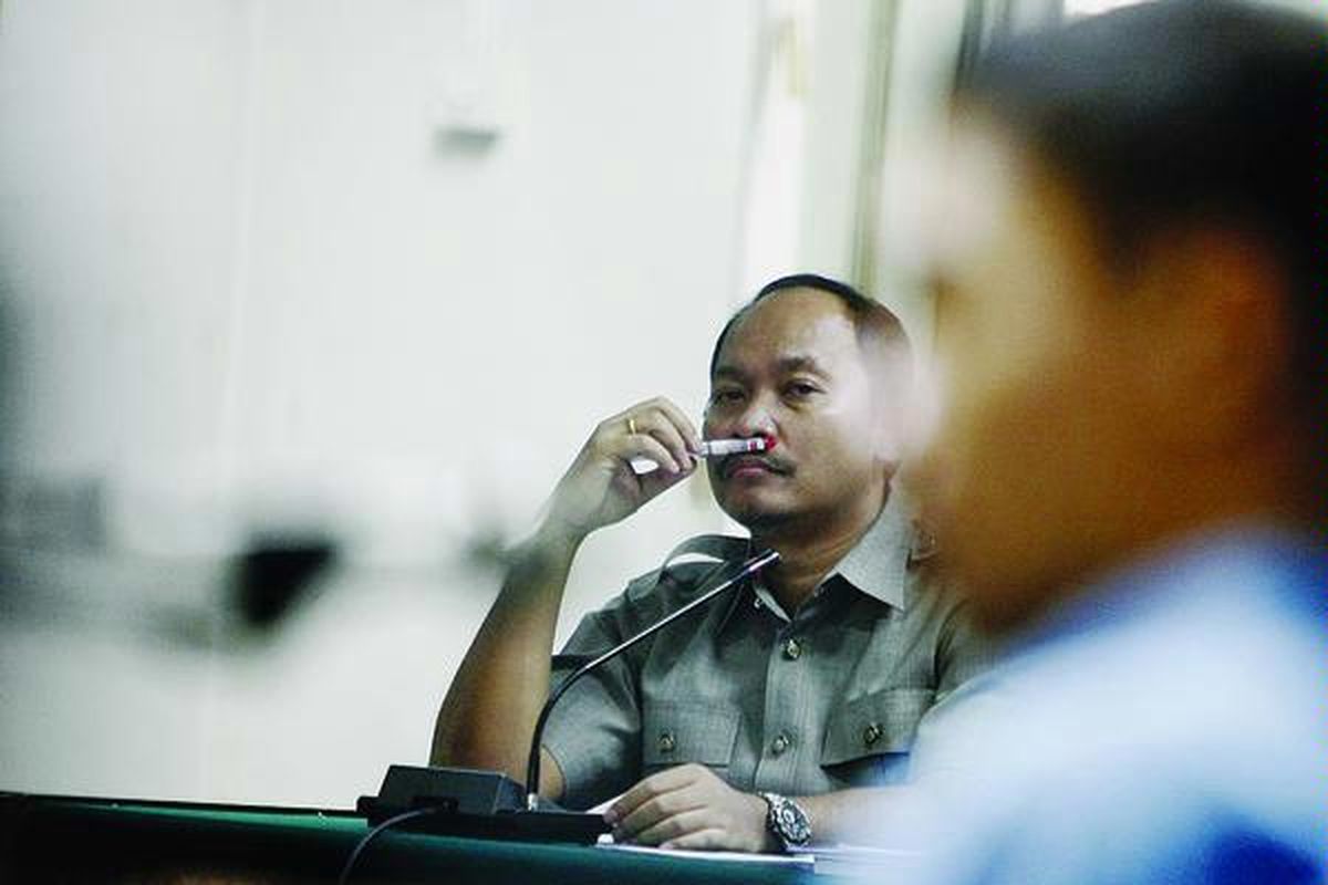 Terdakwa jaksa Urip Tri Gunawan memerhatikan saksi jaksa Hendro Dewanto yang tengah menjawab pertanyaan jaksa penuntut umum dalam sidang dugaan kasus suap 660.000 dollar AS di Pengadilan Khusus Tipikor, Jakarta, Selasa (1/7). Hendro adalah salah satu anggota tim BLBI II pimpinan Urip yang menyelidiki kasus BLBI terkait Bank Dagang Negara Indonesia.  