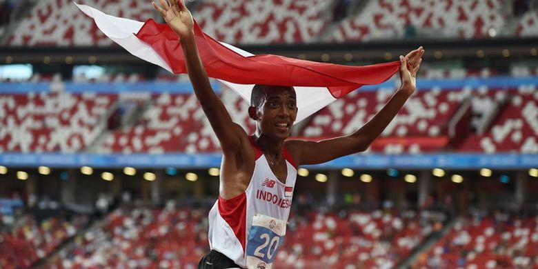 Pelari Indonesia, Agus Prayogo, mengibarkan bendera Indonesia setelah mencapai garis finis lomba lari 10.000 meter SEA Games 2015 di Singapura, 10 Juni 2015.