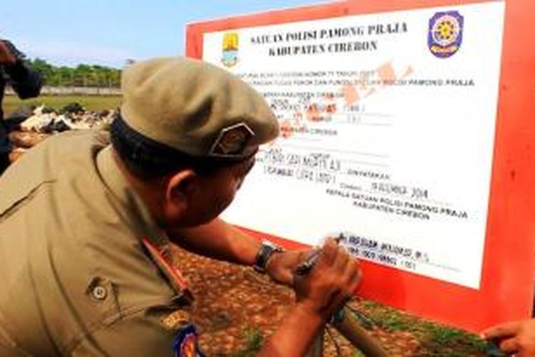 Kasat Pol PP Kabupaten Cirebon menyegel paksa megaproyek perumahan Citraland, PT. Budi Sari Murni Aji, di Desa Pamengkang, Kecamatan Mundu, Kabupaten Cirebon, Jumat Sore, (19/12/2014). 