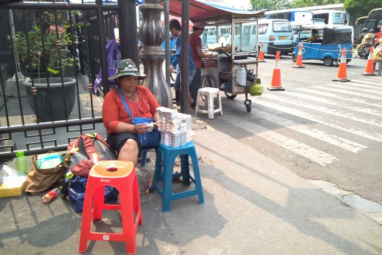 Silalahi (48) menunggu lapaknya di tengah teriknya sinar matahari siang di depan Museum Bank Indonesia, Rabu (6/6/2018).