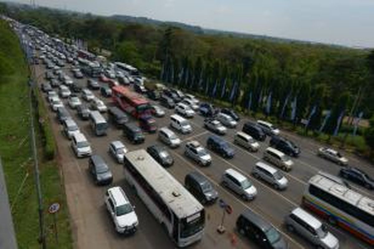 Kendaraan pemudik antre melewati gerbang Tol Cikampek , Kabupaten Purwakarta, Jawa Barat, Kamis (24/7/2014). Dari pukul 00.00 hingga pukul 15.00, sebanyak 23.623 kendaraan telah melewati gerbang tol tersebut dengan puncak jumlah kendaraan yang melintas per jam sebanyak 2.619 kendaraan. Puncak arus mudik di gerbang tol tersebut diperkirakan berlangsung pada, Jumat (25/7/2014). KOMPAS/FERGANATA INDRA RIATMOKO