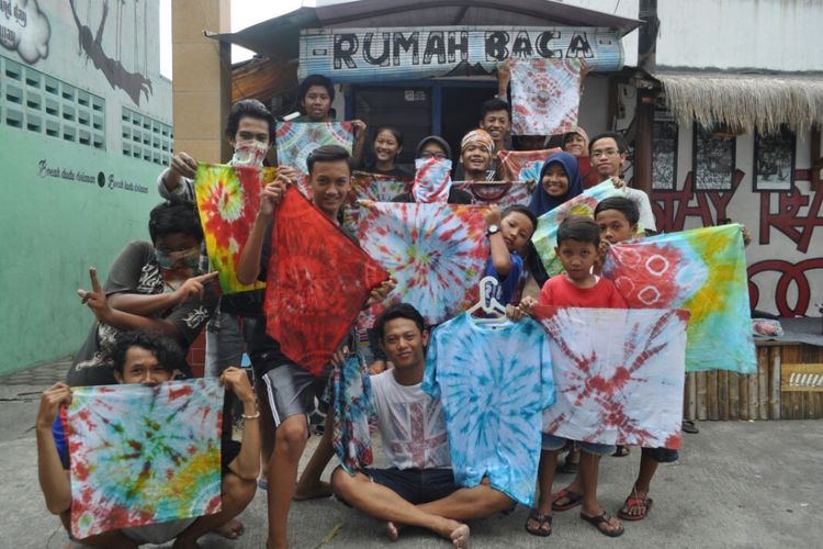 Anak-anak rumah baca Sangkrah menunjukkan hasil karya di depan rumah baca. 