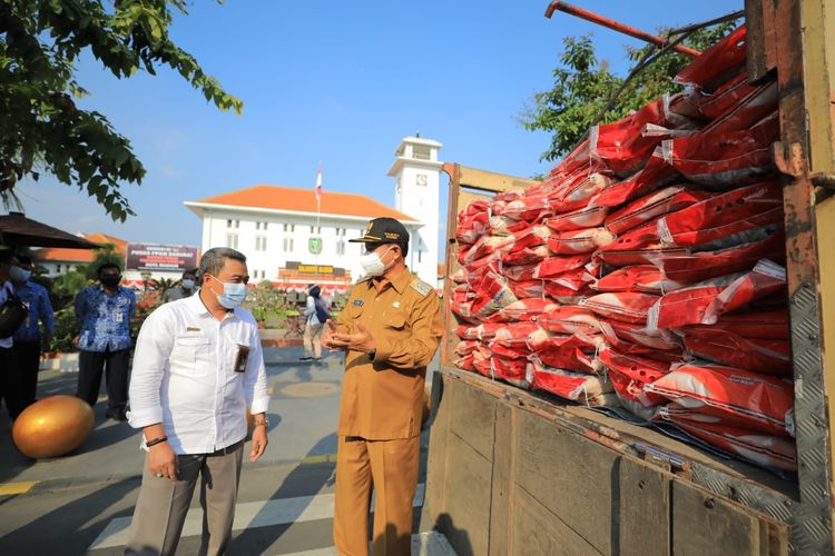 DISTRIBUSIKAN BERAS BANTUAN—Walikota Madiun, Maidi mulai mendistribusikan 139 ton beras bantaun pemerintah pusat pada masa Pemberlakuan Pembatasan Kegiatan Masyarakat (PPKM) Darurat, Senin (19/7/2021). Bantuan itu diperuntukkan bagi 13.952 warga di bumi kota pendekar.