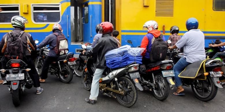 Pengendara motor menerobos palang pintu kereta di kawasan Kemayoran, Jakarta, Rabu (7/11/2012). Minimnya kesadaran keselamatan berkendara membahayakan diri sendiri dan orang lain. 