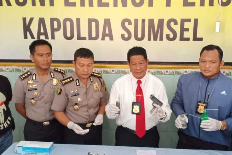 Direktur Reserse Kriminal Umum (Direskrimum) Polda Sumatera Selatan Kombes Pol Yustan Alpiani  (baju putih) menunjukkan barang bukti senjata api rakitan serta narkoba yang didapatkan dari tersangka Sugih alias Bontet, saat gelar perkara di ruang jenazah Rumah Sakit (RS) Bhayangkara Palembang, Rabu (5/2/2020). Sugih ditembak mati petugas karena mencoba melawan ketika akan ditangkap.