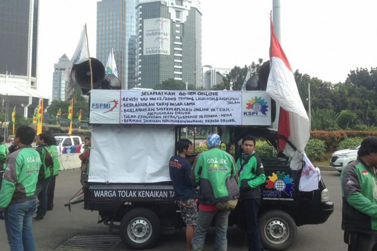 Ratusan pengemudi ojek online berkumpul di samping ruas Jalan Medan Merdeka Barat, Jakarta Pusat, untuk kemudian berunjuk rasa ke depan Kementerian Perhubungan (Kemenhub) dan Istana Negara, Senin (15/5/2017).