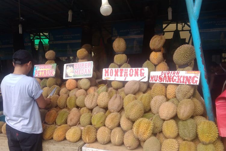 Paul (30), salah satu pedagang durian di Sentra Durian Kalibata, Jakarta Selatan tengah menata buah durian yang dijualnya, Selasa (15/10/2019).