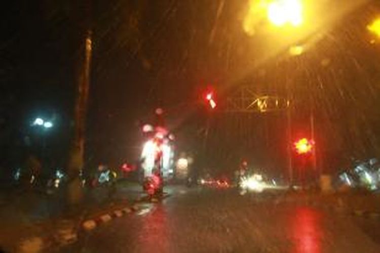 Hujan deras yang mengguyur terlihat di perempatan lampu merah, Jalan Yos Sudarso, Palangkaraya, Kalimantan Tengah (27/10/2015)