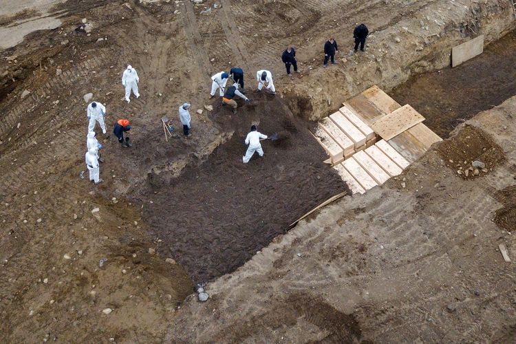 Gambar yang diambil dari drone menunjukkan pekerja sedang menggali kuburan massal di Hart Island, New York, untuk memakamkan para korban meninggal akibat virus corona. Foto diambil pada 9 April 2020.