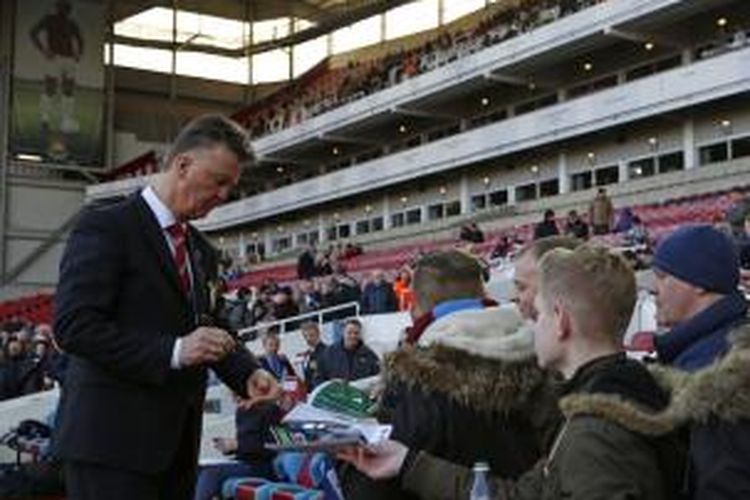 Manajer Manchester United, Louis van Gaal (kiri), melayani permintaan tanda tangan dari suporter, menjelang pertandingan Premier League antara timnya dan West Ham United, di Boleyn Ground, Upton Park, London, Minggu (8/2/2015) pukul 23.15 WIB.