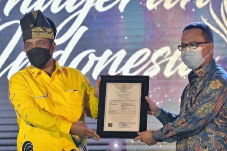 Kadis Pariwisata Riau, Roni Rakhmat (pakai tanjak kiri) saat menerima surat pencatatan inventarisasi kekayaan, intelektual komunal untuk Tanjak Riau dari pihak Kemenkumham RI, Kamis (20/5/2021).
