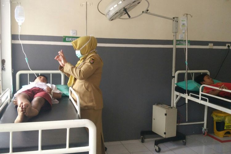 Dokter Puskesmas Ngletih memeriksa kondisi salah satu siswa SDN Tempurejo 1 Kota Kediri yang dirawat karena mengalami pusing dan muntah seusai mengonsumsi coklat, Senin (17/10/2017).