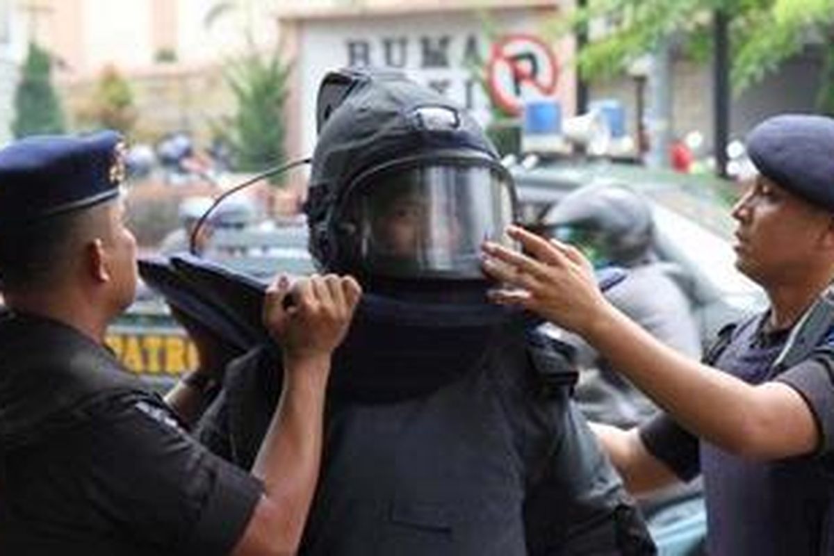 Tim Gegana Polda Riau menggunakan perlengkapan sebelum melakukan pemeriksaan terhadap sebuah kardus yang dicurigai bom di SD Santa Maria, Jalan A Yani, Pekanbaru, Riau, Sabtu (19/3/2011). Setelah dilakukan pengecekan, ternyata kardus yang dicurigai tersebut berisi tropi dan sejumlah buku hasil perlombaan yang dikirimkan via pos berasal dari Jakarta Selatan.