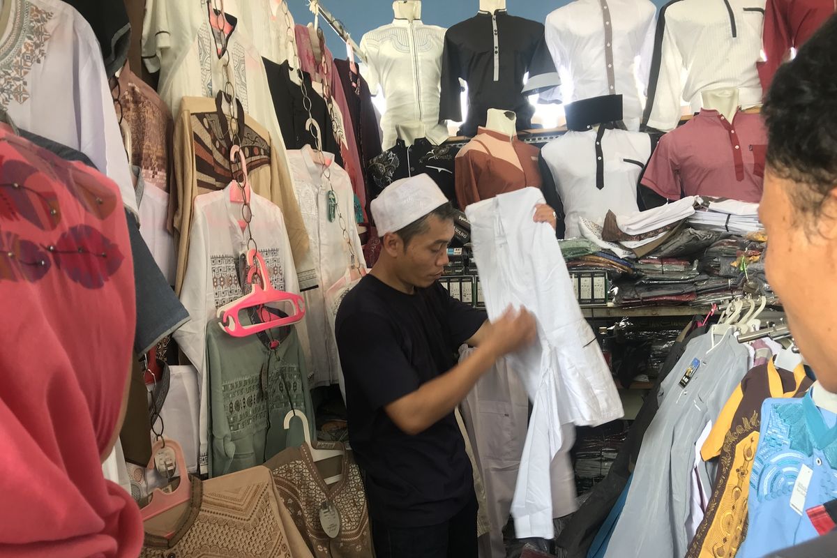 Seorang pedagang baju koko di kawasan Skybridge Pasar Tanah Abang, Jakarta Pusat, Sabtu (4/5/2019) bernama Sutan Syahrir sedang melayani pelanggannya. Jelang Ramadhan para pedagang di Skybridge Pasar Tanah Abang mengaku alami peningkatan omzet hingga 50 persen. 