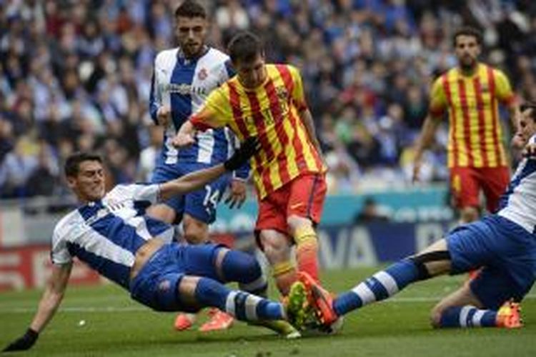 Striker Barcelona, Lionel Messi, saat berusaha melewati hadangan para pemain Espanyol pada lanjutan Liga BBVA di Stadion Cornella-El Prat, Sabtu (29/3/2014).