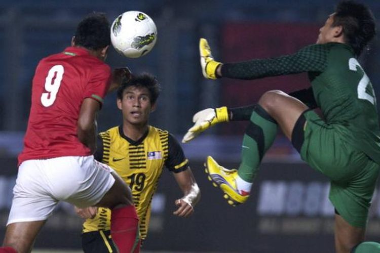 Kiper Timnas U-22 Malaysia, Izdam Tarmizi menahan sundulan pemain Timnas U-22 Abdul Rahman dalam turnamen SCTV Cup di Stadion Utama Gelora Bung Karno, Jakarta, Minggu (9/9/2012).