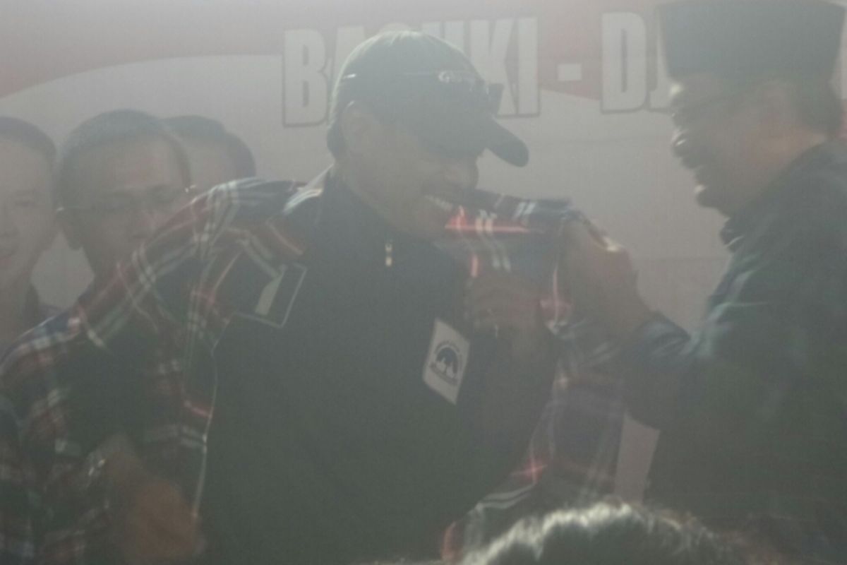 Calon wakil gubernur DKI Jakarta Djarot Saiful Hidayat memakaikan baju kotak-kotak kepada relawan Agus-Sylvi. 