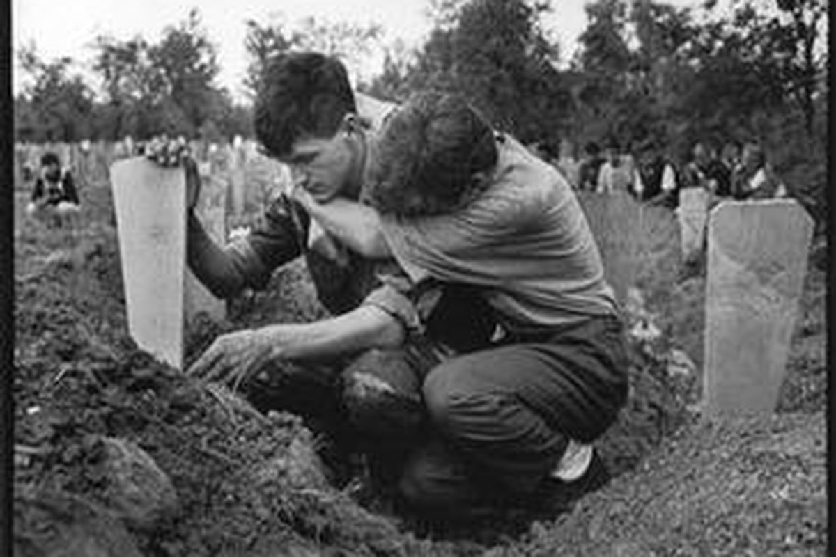 Keluarga korban perang Bosnia di depan makam. 
