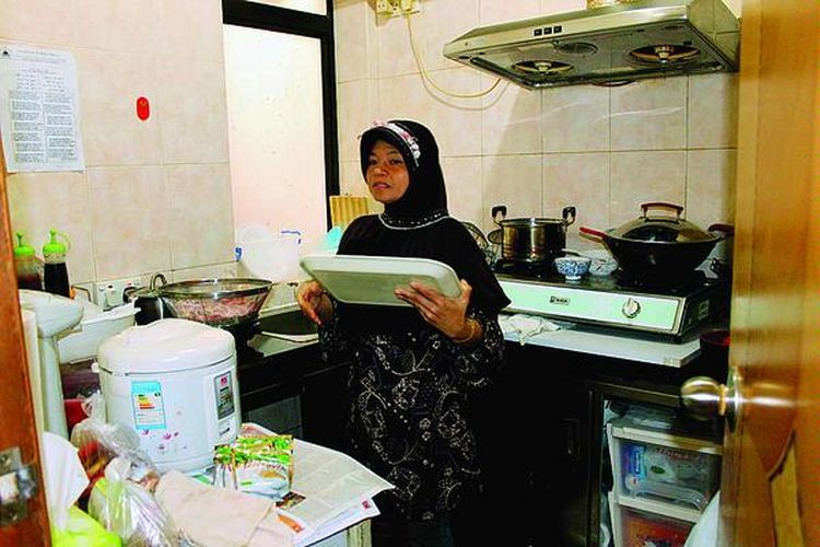 Mukini, salah seorang TKW Indonesia di Hongkong, terlihat beraktivitas di rumah sewaan. Mukini adalah salah satu contoh TKW yang cukup sukses bekerja di Hongkong.