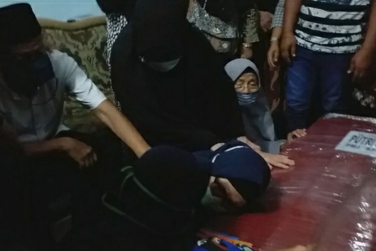 Sang ibu, Ratna, menangis sambil memeluk peti jenazah anaknya, Putri Wahyuni saat tiba di rumah duka di Jalan Sembilang, Kelurahan Limbungan, Kecamatan Rumbai Pesisir, Kota Pekanbaru, Riau, Minggu (17/1/2021). Putri Wahyuni dan suaminya, Ihsan Adhlan Hakim, menjadi korban pesawat Sriwijaya Air jatuh di Kepulauan Seribu, Jakarta.