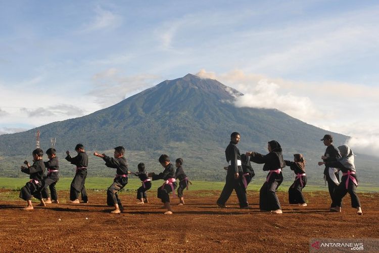 Dok. Foto Pelatih memandu anak-anak latihan silat dengan latar belakang Gunung Kerinci di Perguruan Silat Persaudaraan Setia Hati Terate (PSHT), Desa Lindung Jaya, Kayu Aro, Kerinci, Jambi, Minggu (5/5/2019).