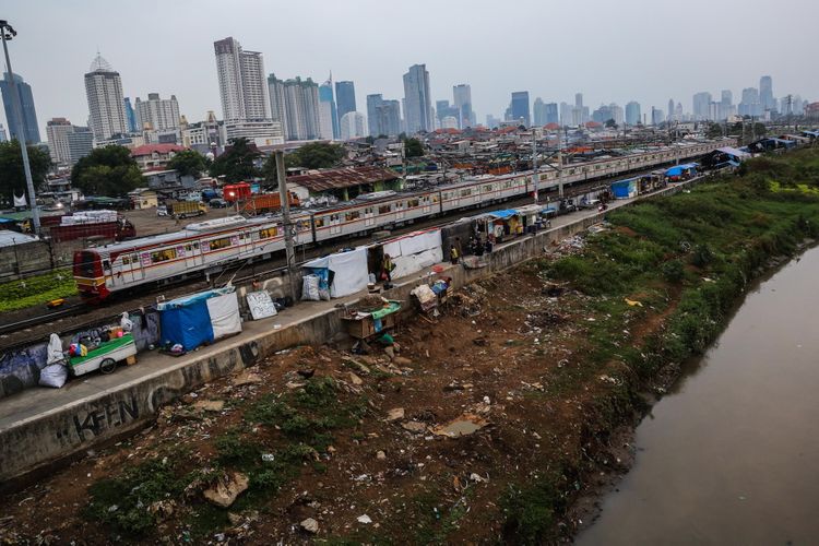 Kereta listrik (KRL) melintas di samping deretan bangunan liar di sepanjang tepi Sungai Ciliwung, Jalan Tenaga Listrik, Tanah Abang, Jakarta Pusat, Sabtu (30/9/2017). Gubuk liar kembali berdiri di sepanjang Sungai Ciliwung akibat kurangnya pengawasan dari Pemprov DKI Jakarta.