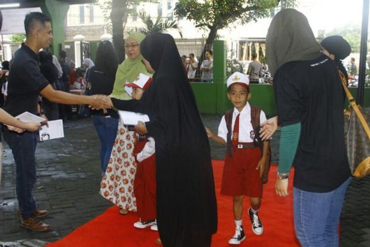 Orangtua dan murid disambut karpet merah oleh Gramedia saat hari pertama masuk sekolah, Senin (18/7/2016). Penyambutan dilakukan di SDN 3 dan 12 Grogol Utara, Kebayoran Lama, Jakarta Selatan.